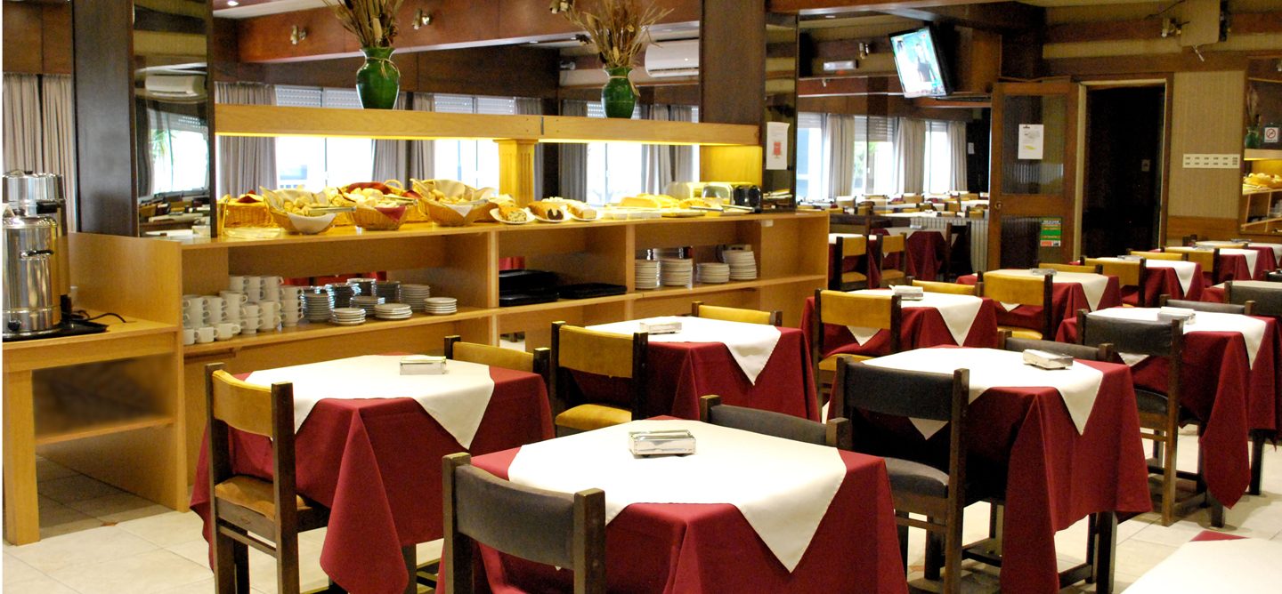 Mostrador del buffet de desayuno con panificados, frutas y termos